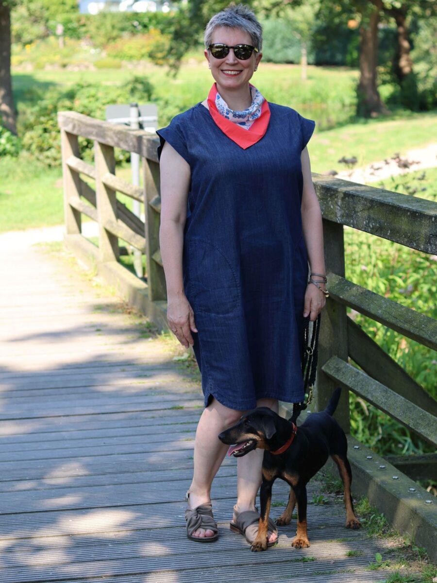 Ines Meyrose - Outfit 2024 - blaues Jeanskleid für den Sommer mit V-Ausschnitt, Nickituch in rot-weiß-blau- Accessoires und Sandalen taupe- Ü50 Bloggerin mit Hund Mona - Foto Nicole