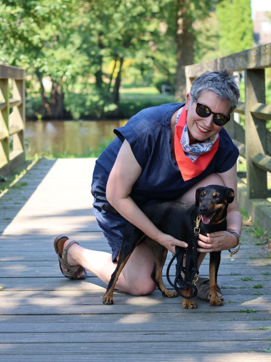 Ines Meyrose - Outfit 2024 - blaues Jeanskleid für den Sommer mit V-Ausschnitt, Nickituch in rot-weiß-blau- Accessoires und Sandalen taupe- Ü50 Bloggerin mit Hund Mona - Foto Nicole