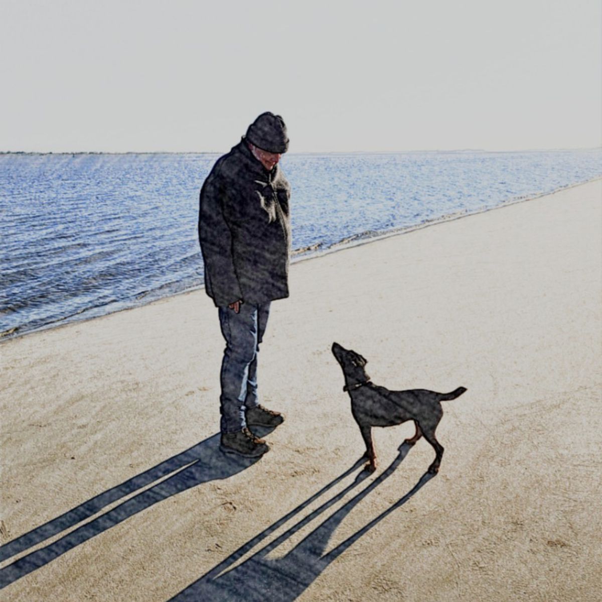 Mann mit Hund am Strand